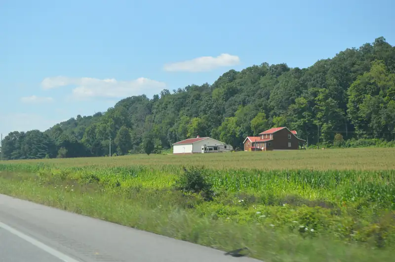 A farmhouse and shed below wooded hills in Green Township